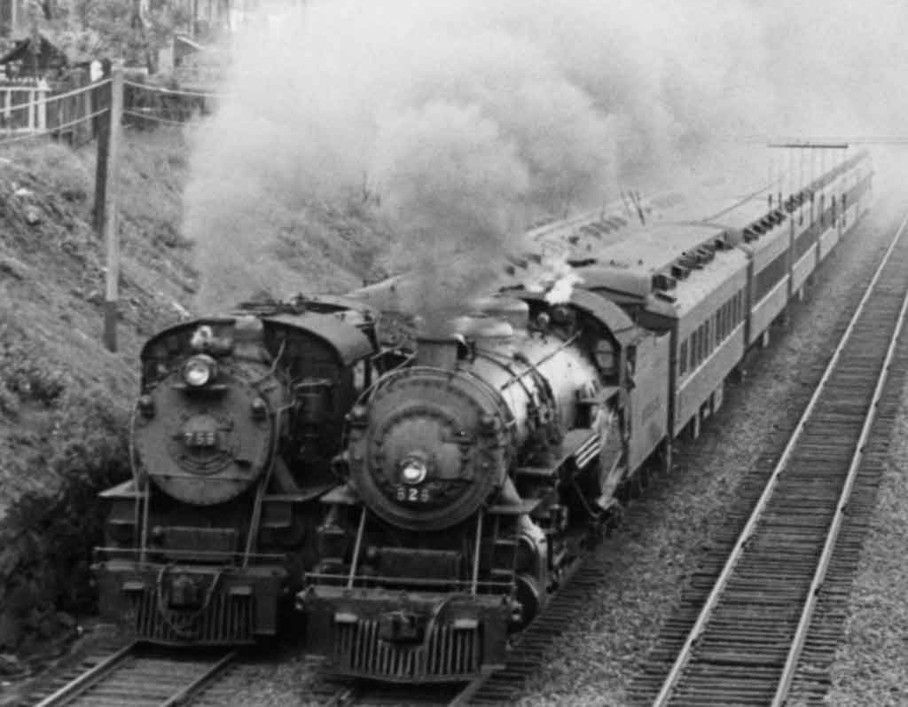 A black and white picture of two trains running side by side