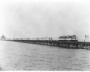 A locomotive crossing a skinny bridge