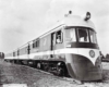 A close up photo of a locomotive with the conductor looking out the window