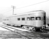 A black and white photo of a tavern lounge car sitting on the tracks