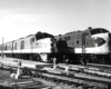 A back and white photo of two locomotives sitting on the tracks