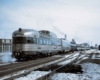 A train departing a city on a cold winter day