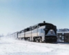 A locomotive travelling through a snowy city