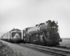 A black and white photo of two locomotives travelling side by side