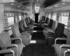 A black and white picture of empty seats inside a train