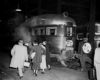 A black and white photo of passengers boarding a train