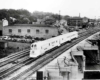 A black and white photo of a locomotive passing over a bridge