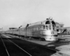 A black and white photo of a train sitting at a station