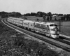 A black and white photo of a train turning a corner