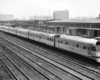 A black and white photo of a train sitting outside a station