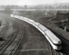 A black and white overhead shot of a train turning a corner