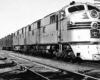 A close up black and white photo of a train sitting on the tracks