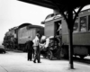 people loading baggage into a baggage car at a depot