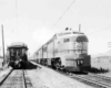 A black and white photo of two trains traveling side by side