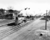 A black and white photo of a train with big white smoke coming out of its chimney