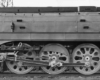 A black and white close up photo of the wheels of a train