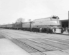 A black and white photo of people boarding a train