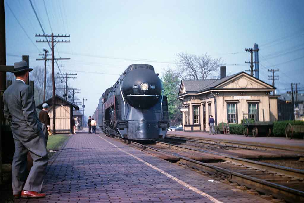 a streamlined passenger train pulling into a depot