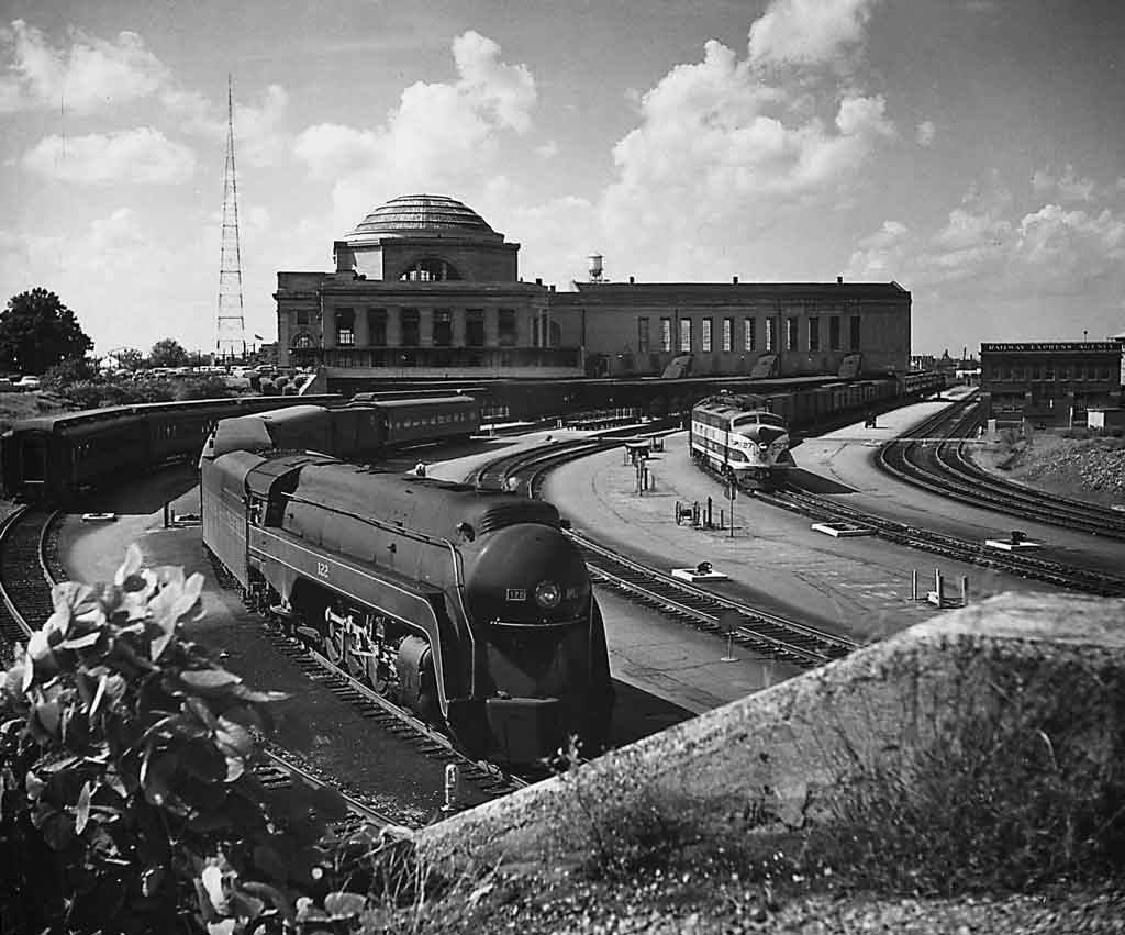a streamlined passenger train departing a station