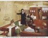 A postcard of a stewardess talking to the passengers in a lounge car