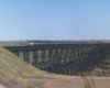 A distant shot of a locomotive crossing a bridge
