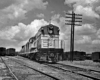 Diesel locomotive with passenger train in freight yard