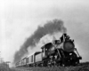 Steam locomotive with five car passenger train at speed