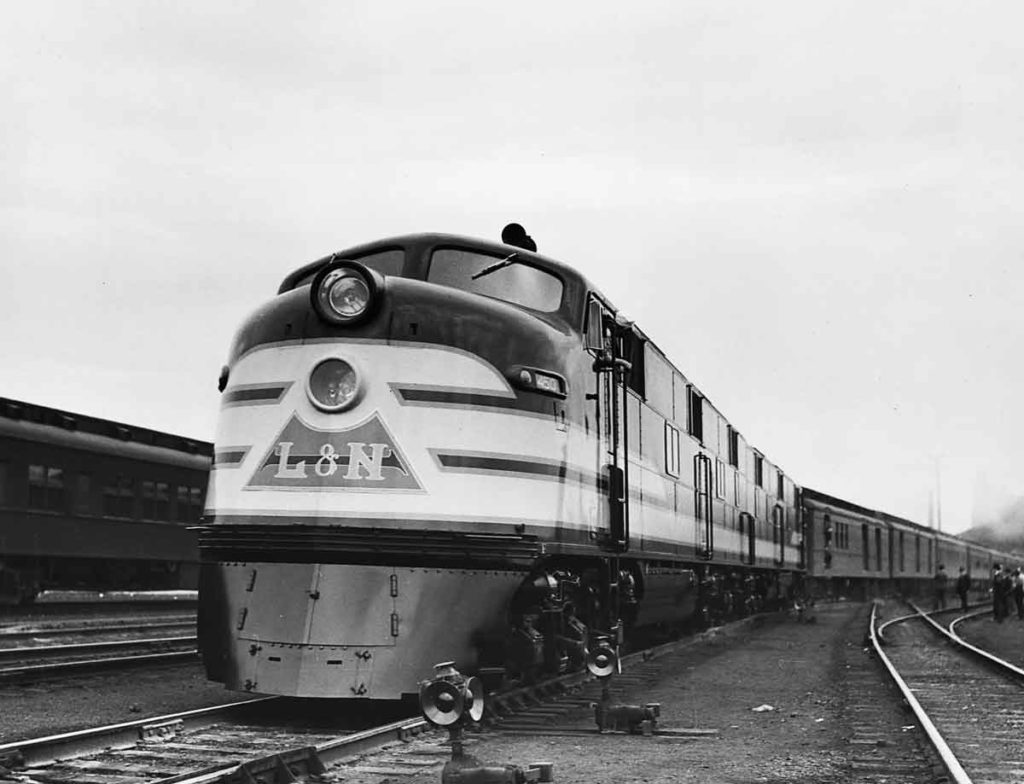 A black and white photo of a train stopped at a station