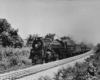 A black and white photo of a train turning a corner