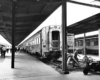 A black and white photo of people walking through a train station