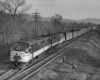 A black and white photo of a train passing by two people