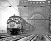 a diesel passenger train crossing a bridge on a snowy day