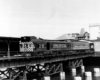 A black and white photo of a locomotive crossing a bridge