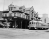 A black and white photo of a train outside a  train station