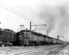 A black and white photo of two trains side by side on the tracks