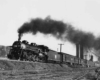 a steam engine pulling passenger cars