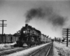 a steam engine pulling passenger cars