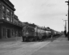 a diesel pulling passenger cars through a town