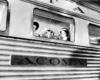 Two ladies smiling through the window of a passenger train