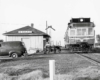 Two men working outside of a passenger train at a train station