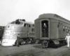 Workers walking around two passenger trains