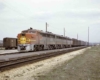 An orange and yellow train sitting on the tracks