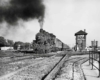 a steam engine passenger train passing a train watchtower