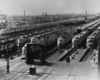 a train yard with 7 passenger trains side by side