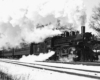 a steam engine pulling passenger cars on a winter day