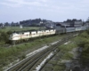 Two diesel electric locomotives haul a passenger train.