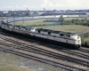 Diesel locomotives leading a passenger train in green, rolling countryside.