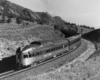 a passenger train rounding a curve with the observation car in the foreground