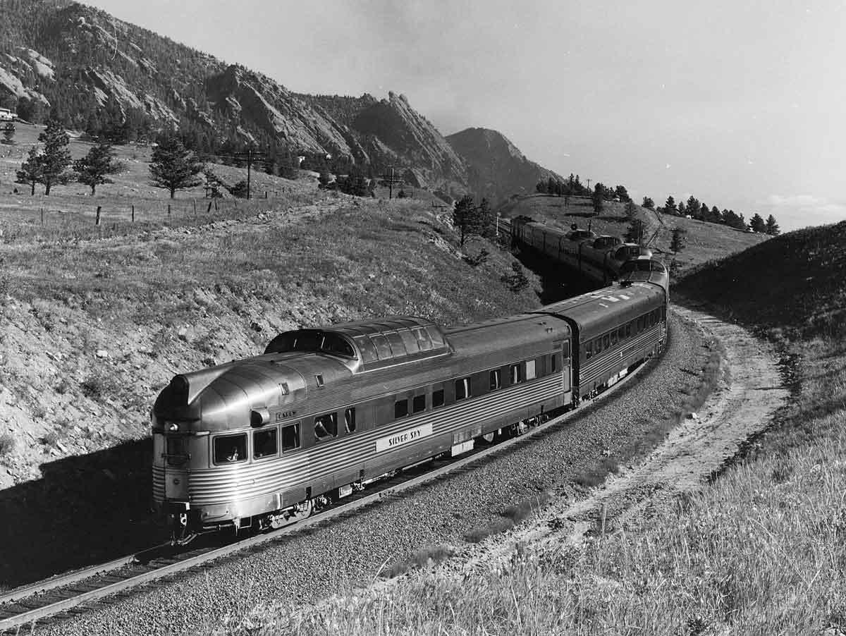 a passenger train rounding a curve with the observation car in the foreground