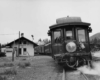 the rear of a passenger train passing a depot